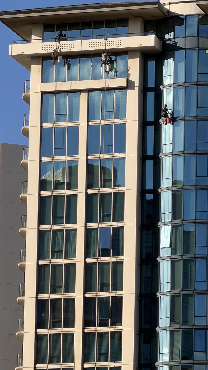 Window cleaners working on the exterior of a residential tower