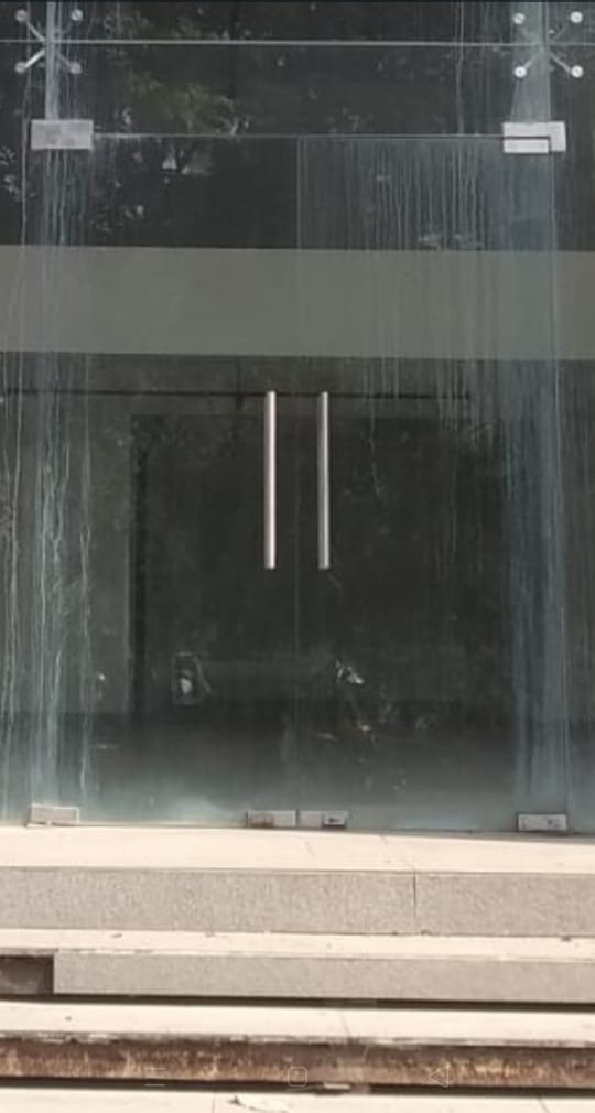 Glass shop-front door before cleaning
